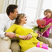 Girl giving her parents a bouquet with a heart