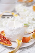Snow globe candle with slices of dried blood orange on plate