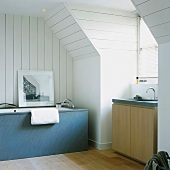 Bathroom with modern bathtub and matching washstand in converted attic