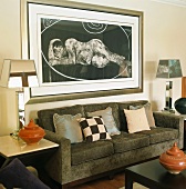 Contemporary artwork over sofa flanked by elegant, mirrored table lamps