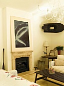 Corner with contemporary picture above fireplace and small boat hung on wall