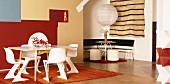 Tische und Stühle in Weiß vor künstlerischer, farbiger Wandgestaltung