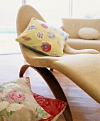 Modern upholstered lounger with floral scatter cushion