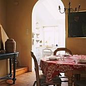 Essraum mit rundem, gedecktem Esstisch, Stühle und Blick in die Küche