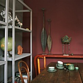 Ausschnitt eines Esszimmers mit rustikalem Holztisch und einfachen Holzregalen