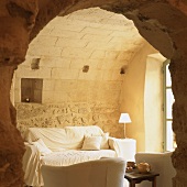 View through rustic doorway into comfortable interior with niches in wall