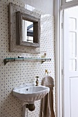Shell-shaped sink with antique tap and square mirror with wooden frame