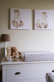 Changing unit with quilted changing mat, teddy bears, table lamp and whimsical nursery pictures above