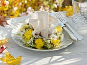 Autumnal place-setting with fabric napkin and flower wreath
