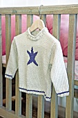 Child's knitted jumper on coat hanger