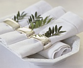 Napkins with napkin rings & sprig of pistachio foliage