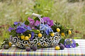 Hydrangeas, damsons and mirabelles in a wire basket