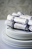 A stack on plates with Christmas crackers on top