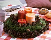 Advent wreath of pine and pine cones with candles