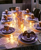 Romantisch gedeckter Tisch mit Teelichten am Abend