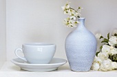 Weisses Stillleben mit Kaffeetasse, Vase und Zierkirsche