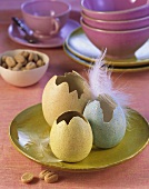 Easter decoration: three coloured eggshells with feather