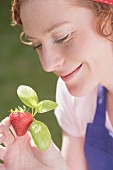Junge Frau mit Erdbeere und Basilikum