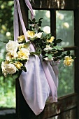 Eine Tasche mit Rosen an einer Tür hängend