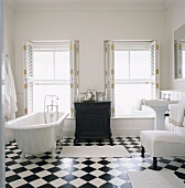 Ein Badezimmer mit Fliesenboden in Schachbrettmuster und freistehende Badewanne