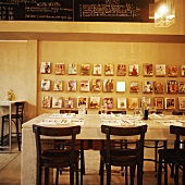 Gedeckter Tisch in einem Restaurant vor Holzwand mit ausgestellter Zeitschriften-Sammlung