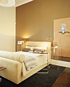 Modernes Schlafzimmer mit gepolstertem Bettgestell und Beistelltisch
