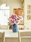 Pfingstrosen in einer blauen Vase auf einem Küchentisch