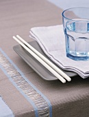 A plate with glass and chopsticks