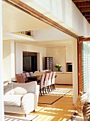 View through open terrace door of dining area and doorway to kitchen in open-plan interior