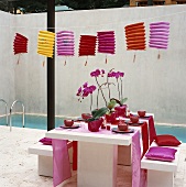 Cheerful courtyard with pool, lanterns and festively set table