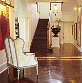 Large, grand hallway with glossy parquet floor and staircase