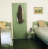 Grüne Holztür aus Holzlatten zwischen zwei Einzelbetten