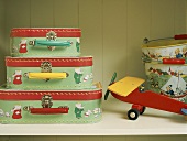 Children's suitcases and model plane on shelf
