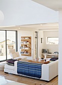 Weißes Ecksofa und Designerliegestuhl aus Leder im offenen Wohnraum eines Architektenhauses