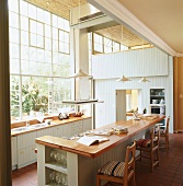 Elegante Vintageküche in einem aussergewöhnlichen Loft mit großen Industriefenstern und Terrakottaboden