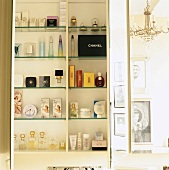 Perfumes & toiletries in open bathroom cabinet