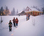 Menschen mit Kerzen in Winterlandschaft