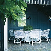 Überdachte Terrasse mit runden Tisch und Rattansesseln
