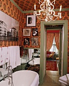 Ein offenes Badezimmer mit bunter Tapete und Bildern