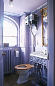 Romantisches Badezimmer mit rundem Fenster und violetten Wänden