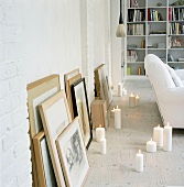 Kerzen und angelehnte Bilder am Boden eines Wohnzimmers