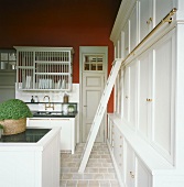 Traditionelle Küche mit einer Leiter zu den oberen Küchenschränken und mit einem Küchenblock