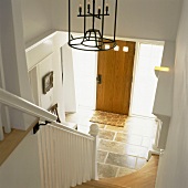 Blick von der Treppe zum Eingangsbereich mit einer Holztür und opaken Lichtfenstern