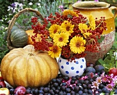 Autumnal still life with vase of flowers, pumpkins & fruit