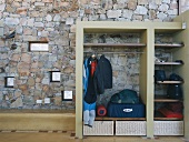 Integrierte Garderobe mit dunklen Holzböden vor einer Natursteinwand