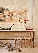 Wandtisch mit Rosen und moderner Kunst an einer strukturierten Wand