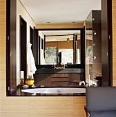 Modernes, holzvertäfeltes Badezimmer in Brauntönen mit großem Wandspiegel