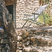 Weisser Liegestuhl vor einem Rustico