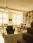 Ein heller Raum mit Töpferwaren in einer Regalwand und vielen Sitzmöglichkeiten