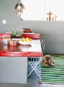 Bunte Schalen auf einem ausgefallenen Steintisch mit roter Tischplatte